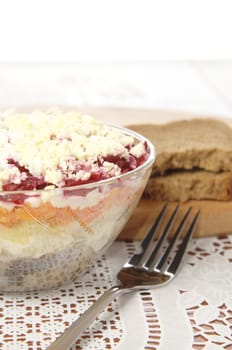 Russian traditional herring salad in glass bowl