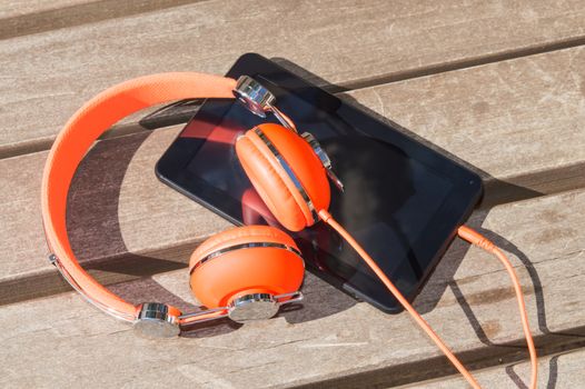 Orange headphones and tablet pc for mobile audio language course learning 
