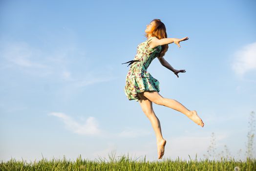 Happy Young Woman Jumping over blue sky