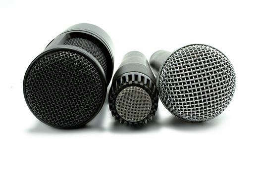 one condenser microphone and two dynamic microphones, isolated on white background