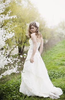 Portrait of beautiful blond bride in spring blossom