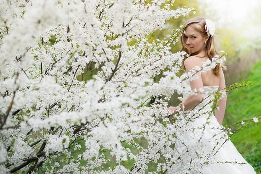 Portrait of beautiful blond bride in spring blossom