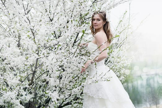 Portrait of beautiful blond bride in spring blossom