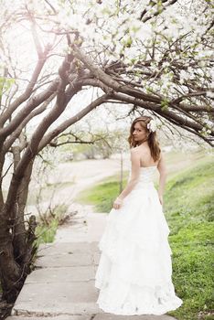 Portrait of beautiful blond bride in spring blossom