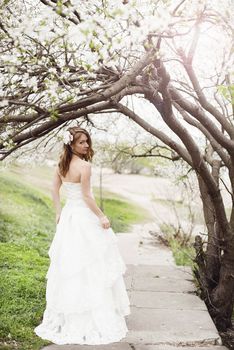 Portrait of beautiful blond bride in spring blossom