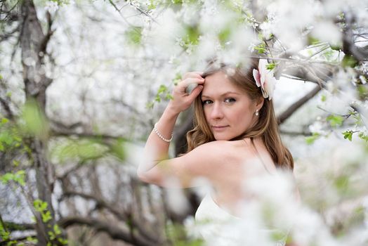 Portrait of beautiful blond bride in spring blossom