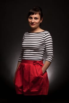 stylish expressive woman with red trousers on black background