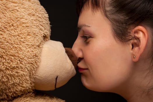 portrait of a stylish expressive woman with teddy bear in studio