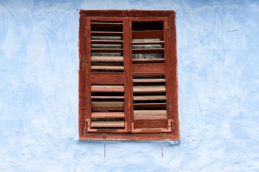 vintage, old brown wooden window on blue wall
