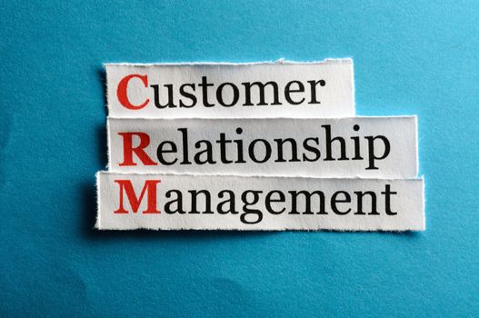 CRM customer relation management abbreviation on blue paper