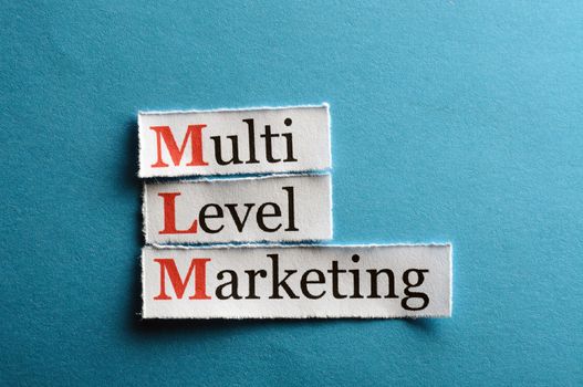 mlm - multi level marketing on blue paper