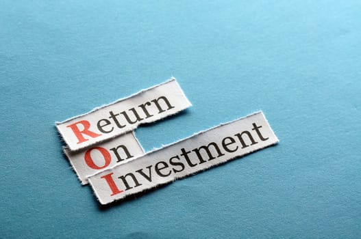 ROI acronym on blue paper , Return On Investment