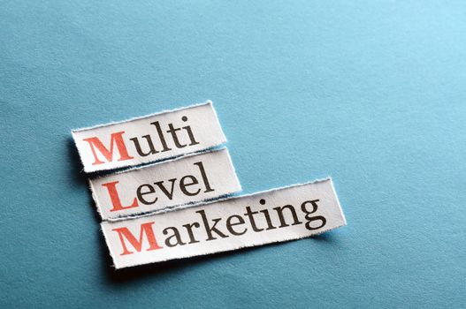 mlm - multi level marketing on blue paper