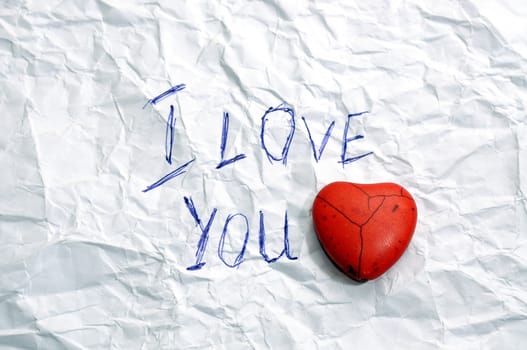 message I Love You on wrinkled paper and red  heart 