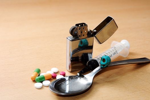 syringe, spoon,pills,skull  and lighter on the floor