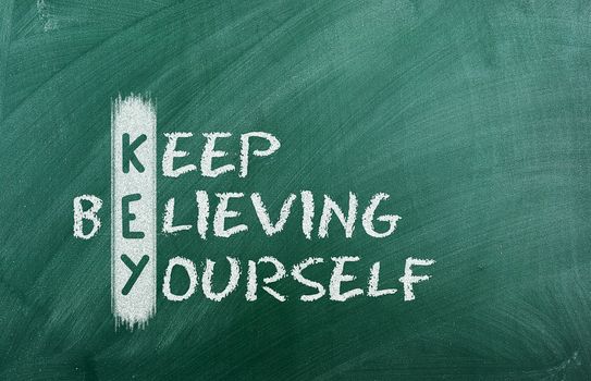 Acronym of KEY. Believe in yourself written in chalk on a blackboard .