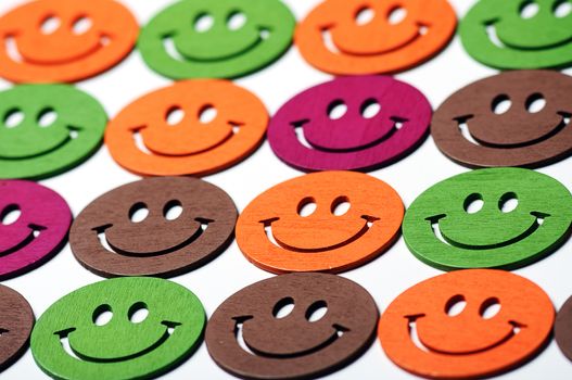 smiling wooden multi colored emoticons in row