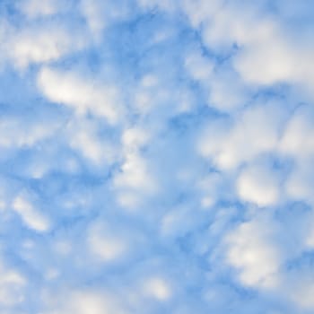 The blue sky and white fluffy clouds .