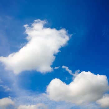 The blue sky and white fluffy clouds .