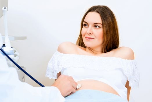 Young attractive pregnant woman on reception at the doctor, health check