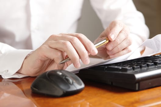 Hands with a document on a computer keyboard