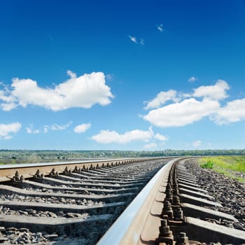 railroad to horizon under blue cloudy sky