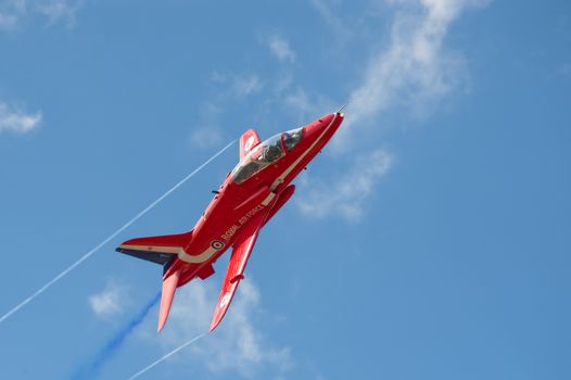 Farnborough, UK - July 15, 2010: Banking maneuver by a Red Arrows aerobatic display jet during the Farnborough International Airshow, UK