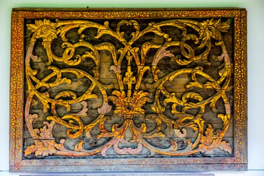 detail of wood carving with thai pattern on natural wood plate for decorated temple,Thailand