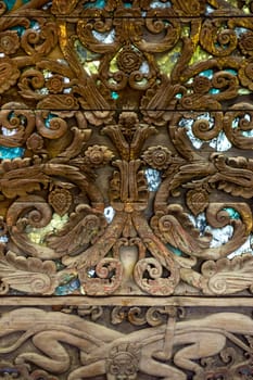 detail of wood carving with thai pattern on natural wood plate for decorated temple,Thailand