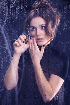 Portrait of a woman with an eyelash curler for eyelashes