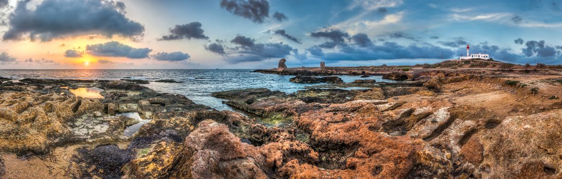 sunset over the sea and rocky coast with ancient ruins