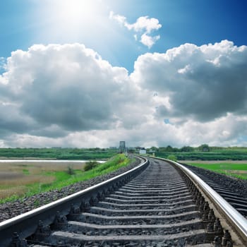 sun over clouds and railroad