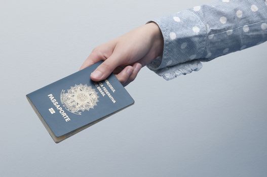 Caucasian Woman holding a brazilian passport / A passport is a government-issued document that certifies the identity and nationality of its holder for the purpose of international travel.