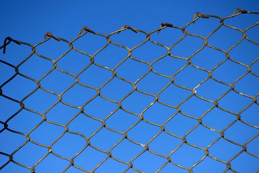 Steel net fence with blue sky background.