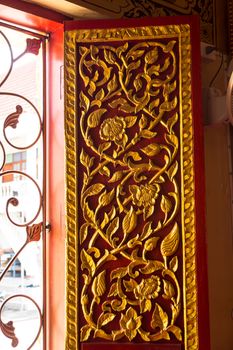 detail of wood carving with thai pattern on natural wood plate for decorated temple,Thailand