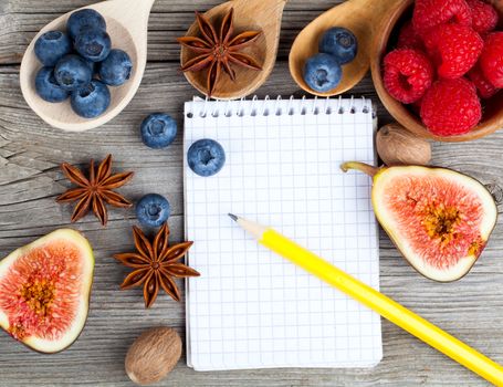 top view of recipe book with ingredients on wooden table