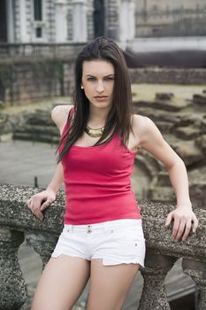 Attractive young woman leaning against stone balusters