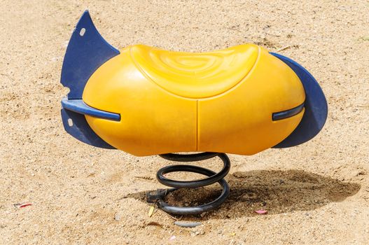 Yellow bench on spring on playground 