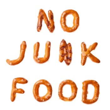 Words NO JUNK FOOD written, laid-out, with crispy alphabet pretzels isolated on white background