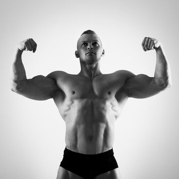 Fitness, bodybuilding. Powerful man on a white background