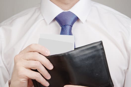 Businessman holding black wallet full of money