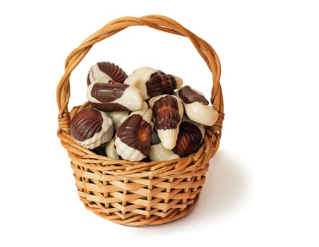 The wattled basket filled with tasty chocolates. It is presented on a white background