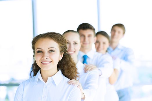 portrait of a young business woman standing in line with colleagues, concept of teamwork