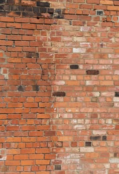 distressed looking wall showing repairs with new bricks