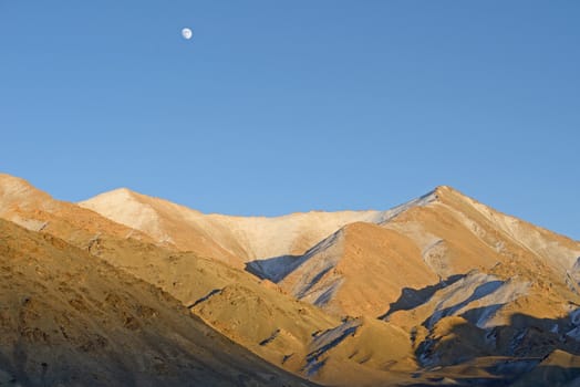 moon at Himalaya high mountain road pass Leh highway over blue sky. Ladakh, India.
