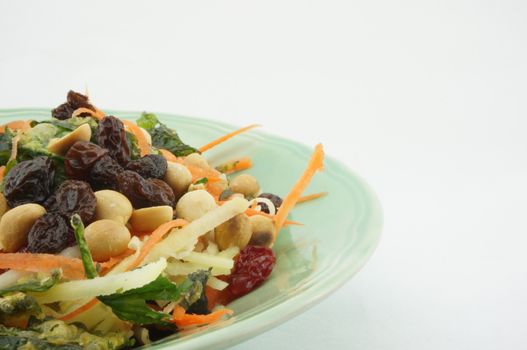 Healthy Salad consists apple carrots mango raisins nut and tomatoes.