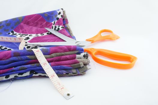 New fabric colors for a beautiful tailor with scissors and a tape measure.