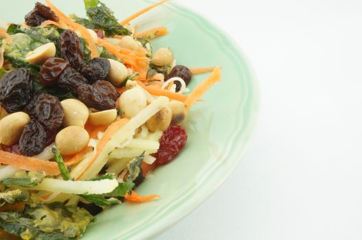 Healthy Salad consists apple carrots mango raisins nut and tomatoes.