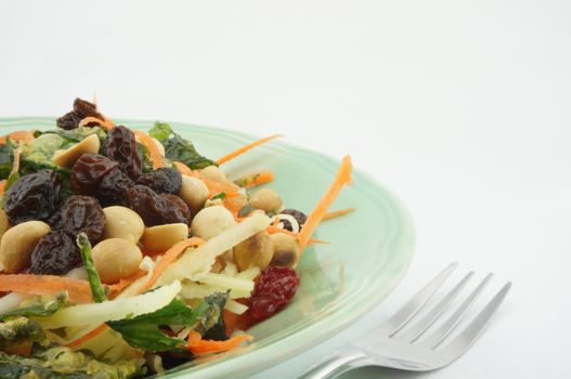 Healthy Salad consists apple carrots mango raisins nut and tomatoes.