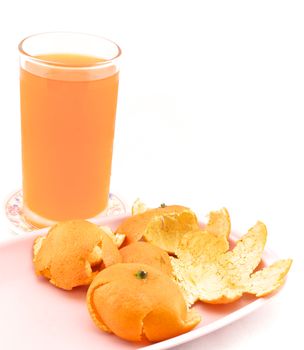 Cold orange juice in glass placed on coasters and orange peel with white background.